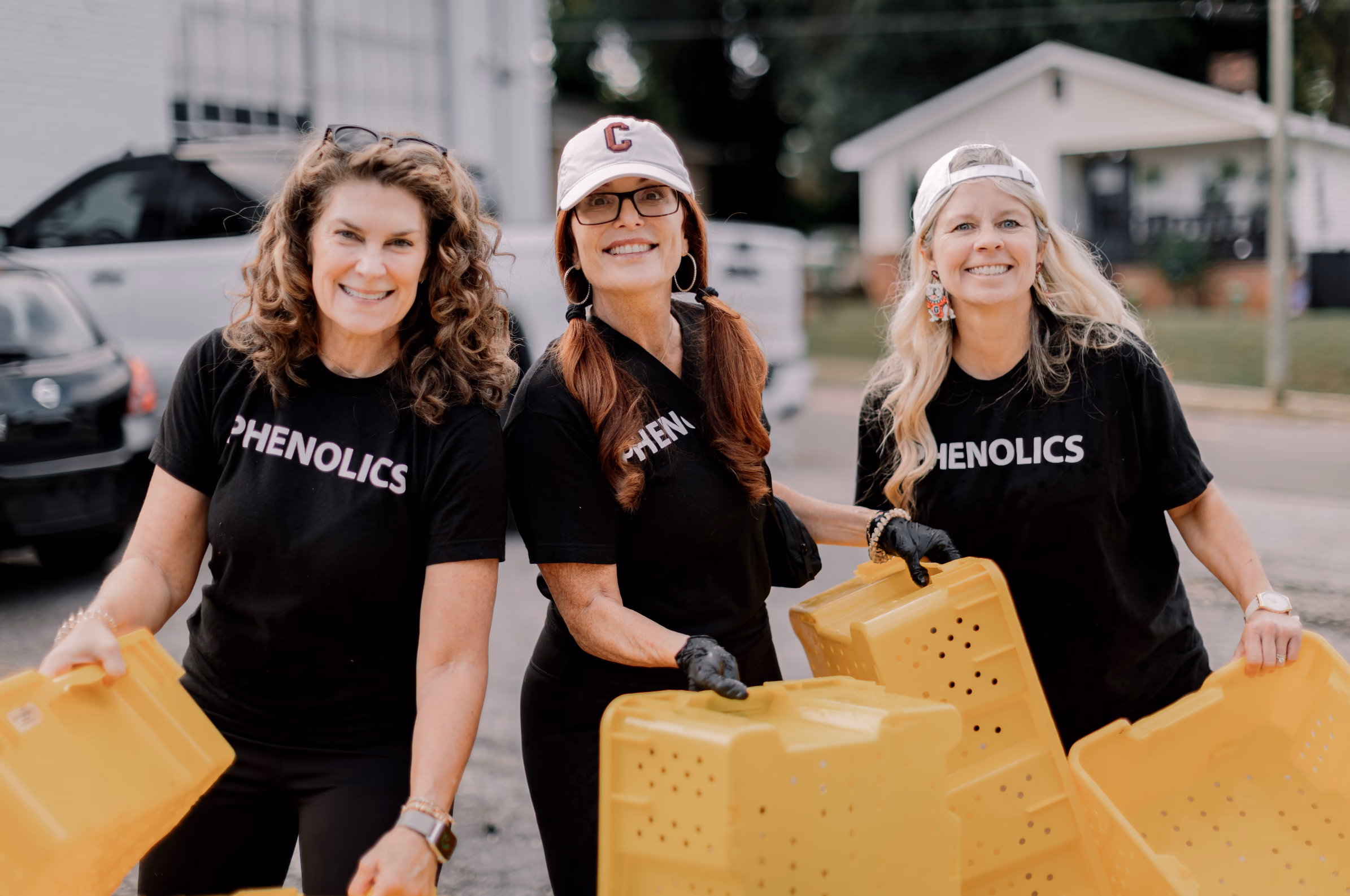 Three members of the Phenolics harvest team carrying grape bins